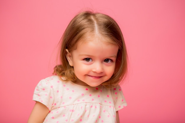 Foto niña que sonríe en fondo rosado