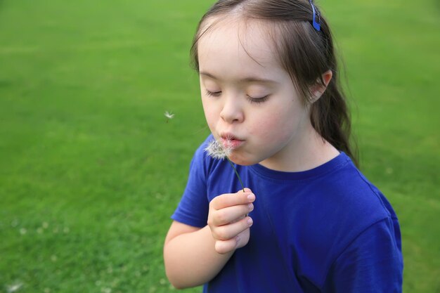 Niña que sopla el diente de león