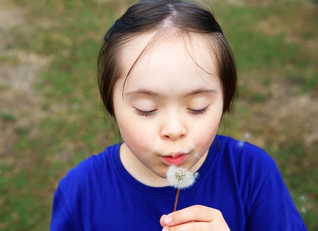 Niña que sopla el diente de león