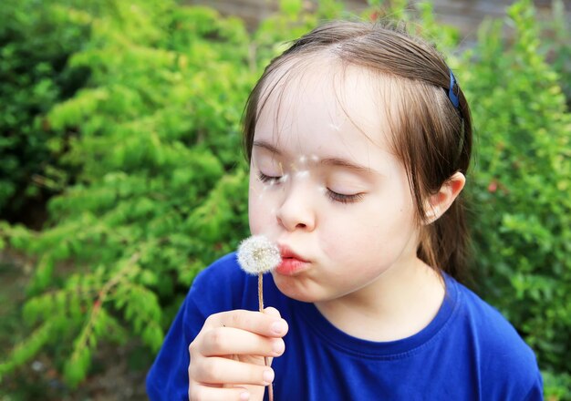 Niña que sopla el diente de león