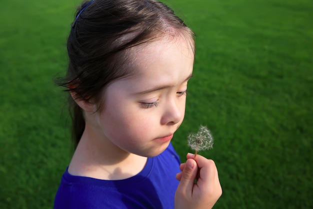 Niña que sopla el diente de león