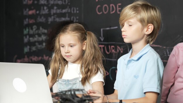 Niña que usa una computadora portátil programando código de ingeniería y escribiendo programas Erudición