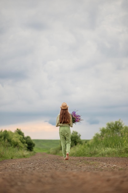 niña con un ramo de flores va por el camino