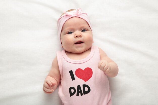 Bebé Recién Nacido Niña En Camiseta Con Inscripción Me Encanta Papá Mirando  Cámara. Día De San Valentín Foto de archivo - Imagen de riéndose, regalo:  208126628