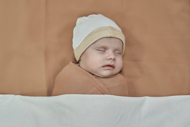 Niña recién nacida durmiendo envuelta en una manta marrón