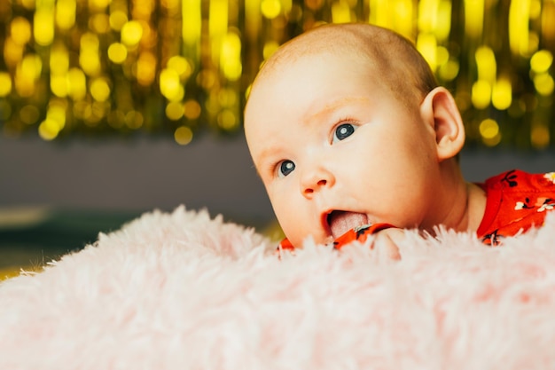 Niña recién nacida con ojos azules en una manta rosada