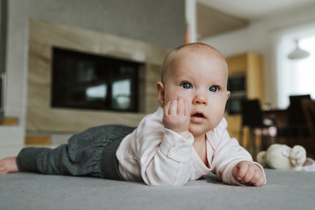 Niña recién nacida en el suelo con mano gesto italiano