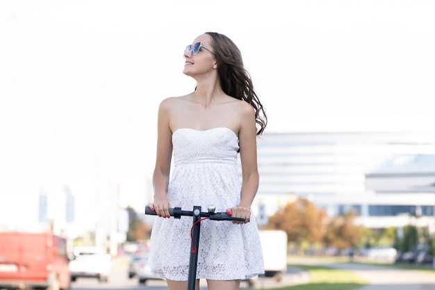 Una niña recorre la ciudad en un scooter eléctrico cuando hace buen tiempo.