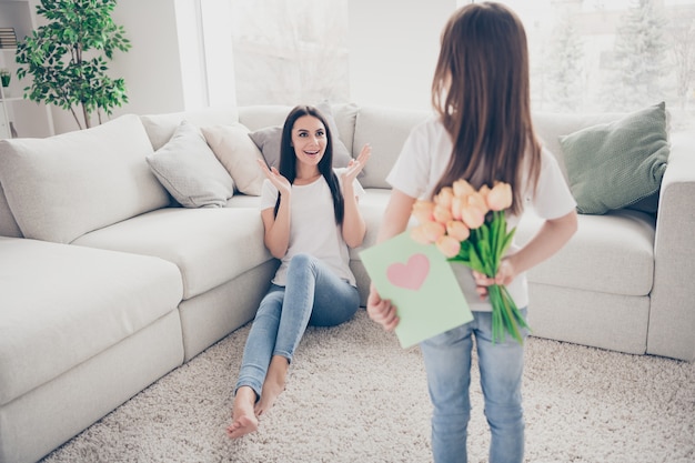 Niña regalar a mamá ramo de flores tarjeta de felicitación en casa en el interior