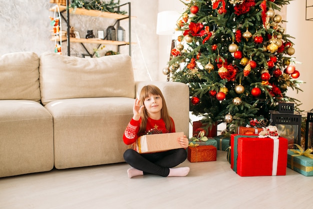 Niña con regalo de Navidad en casa