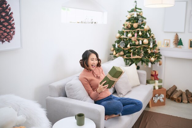 La niña con regalos cerca del árbol de Navidad.