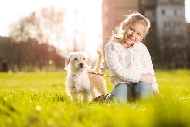 Niña relajándose con su cachorro en el parque