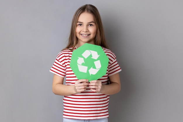 Niña responsable con camiseta sosteniendo en las manos el reciclaje verde canta el concepto de ecología