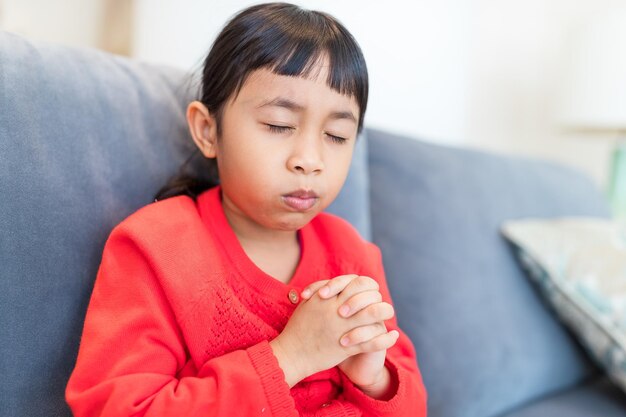 La niña reza en casa