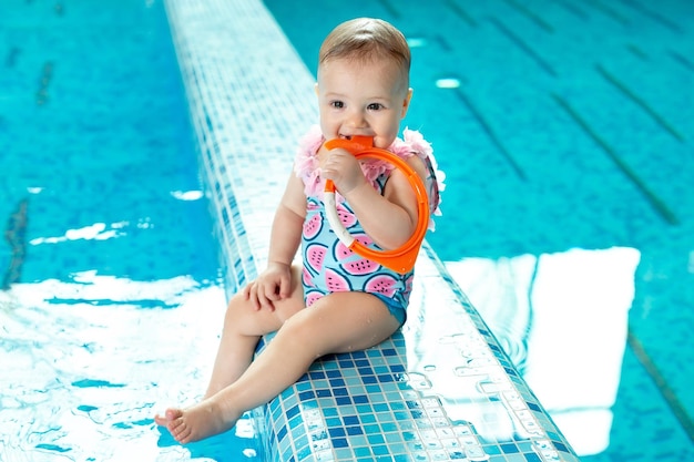 Foto la niña se ríe en la piscina en una lección de natación