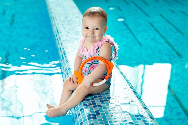 La niña se ríe en la piscina en una lección de natación.