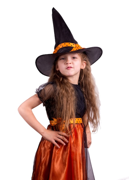 Foto niña riendo feliz vistiendo un disfraz de carnaval de brujas jugando con una canasta de golosinas. niño niña niño de halloween sobre un fondo blanco.