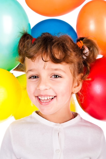 Niña riendo con globos de colores