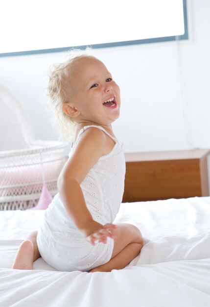 Niña riendo y jugando en la cama