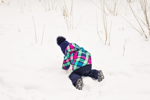 Niña riendo jugando en la nieve.