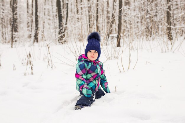 Niña riendo jugando en la nieve.