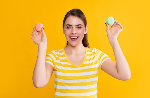 Niña riendo con macaron sobre fondo amarillo