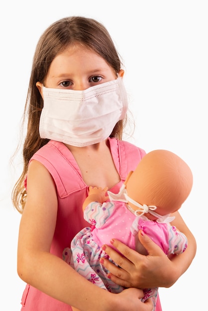 Niña con rimel y jugando con su muñeca