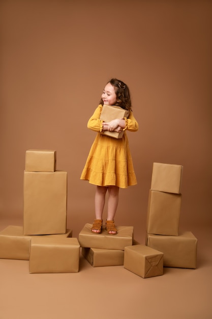 Foto niña rizada con gran pila de regalos para las vacaciones