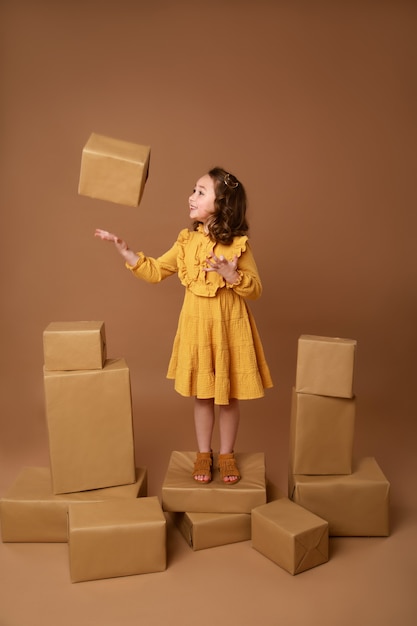 Niña rizada con gran pila de regalos para las vacaciones