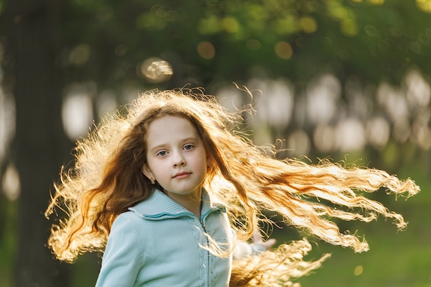 Niña rizada con pelo pelirrojo volando.