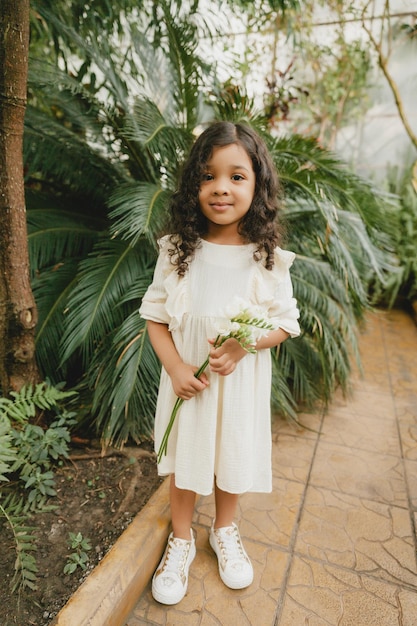 Niña rodeada de hojas tropicales Retrato de un niño moreno con cabello oscuro Cosmética natural salud limpieza