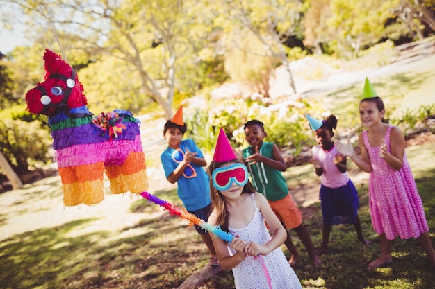 Foto niña va a romper la piñata por su cumpleaños