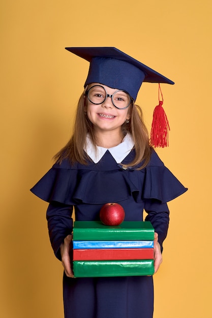 Niña en ropa académica con libro