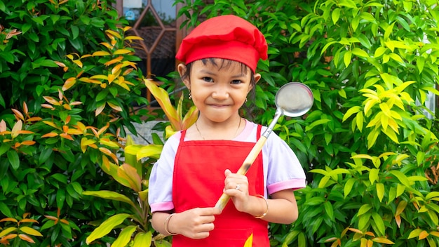 Niña con ropa de cocina roja