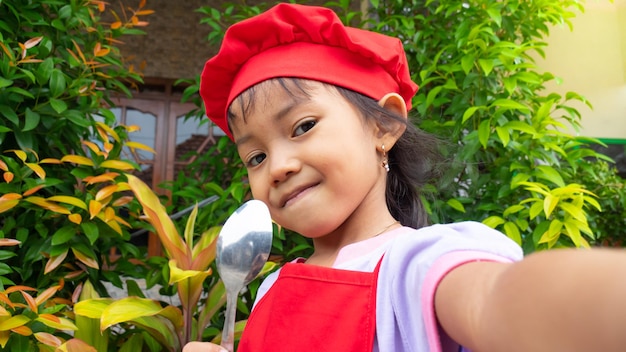 Niña con ropa de cocina roja