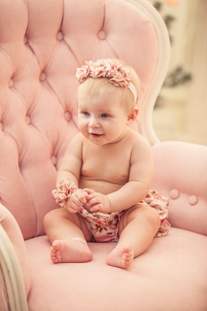 Niña en ropa rosa y feliz interior en estilo retro