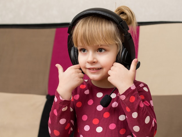 Niña rubia en los auriculares sonriendo