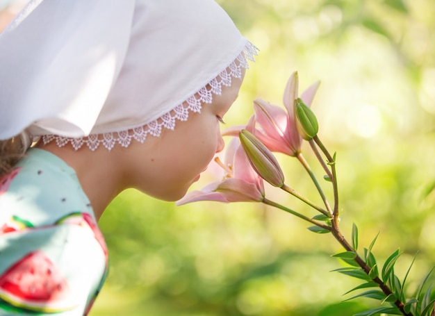 una niña rubia bebé camina en un día soleado cuida el jardín