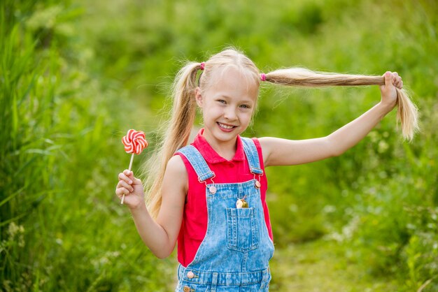 Niña rubia con cabello largo y un caramelo