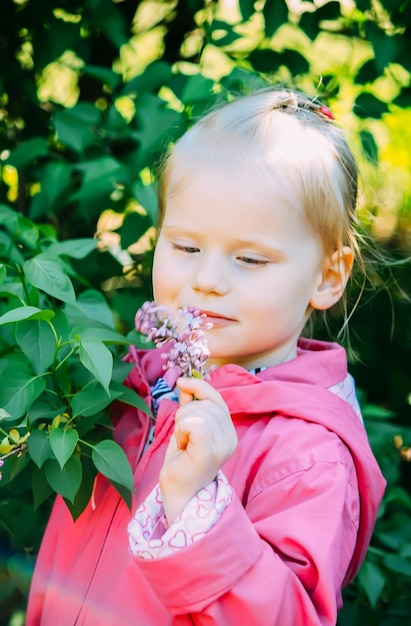 Niña rubia camina en un parque de primavera