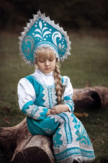 Niña rubia en un disfraz de hada rusa