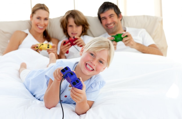 Niña rubia jugando videojuegos con su familia