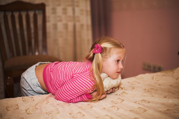 Niña rubia con un juguete suave