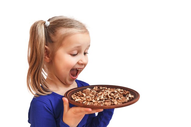 Niña rubia sosteniendo un plato de nueces