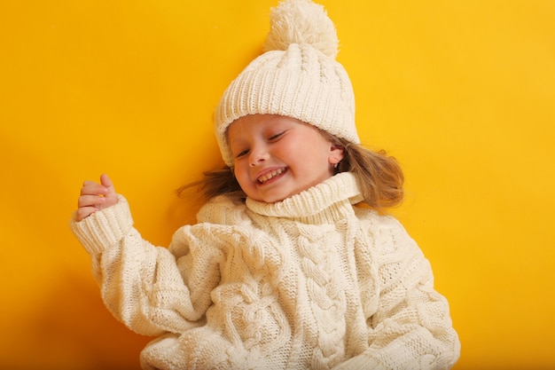 Niña rubia en un suéter de punto blanco retrato grande