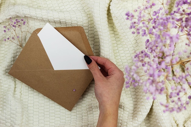 La niña saca una hoja en blanco de un sobre de manualidades. Diseño de invitación y tarjeta de felicitación.