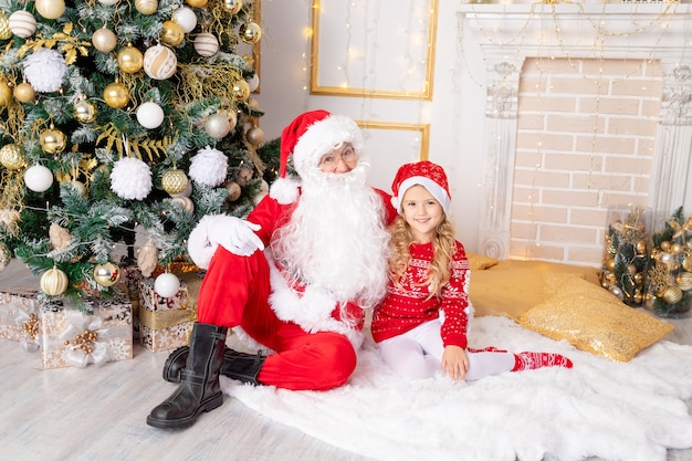 Niña con Santa Claus en el árbol de Navidad