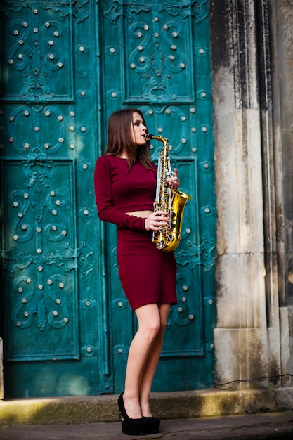 Niña con saxofón jugando en la calle