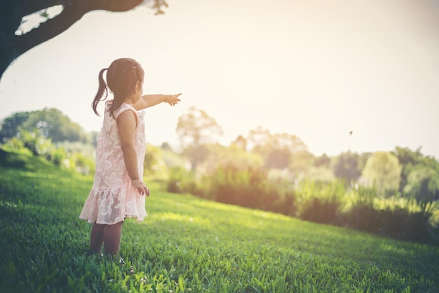Niña señalando mientras está de pie en el parque