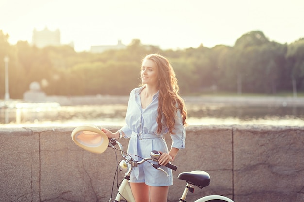 Niña sentada al lado de la bicicleta